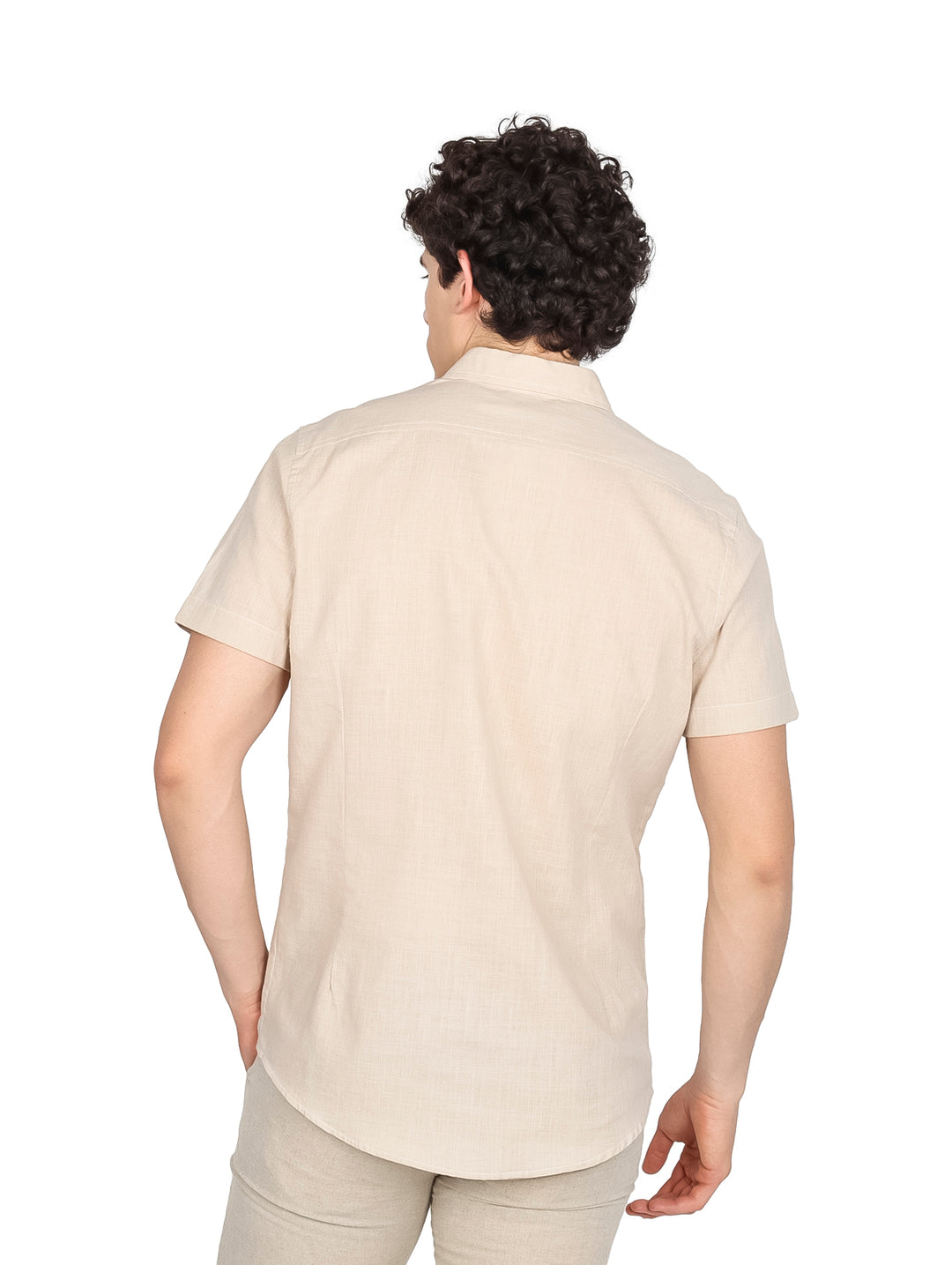 Hombre vistiendo camisa de manga corta color khaki con un bolsillo en el pecho y botones frontales.