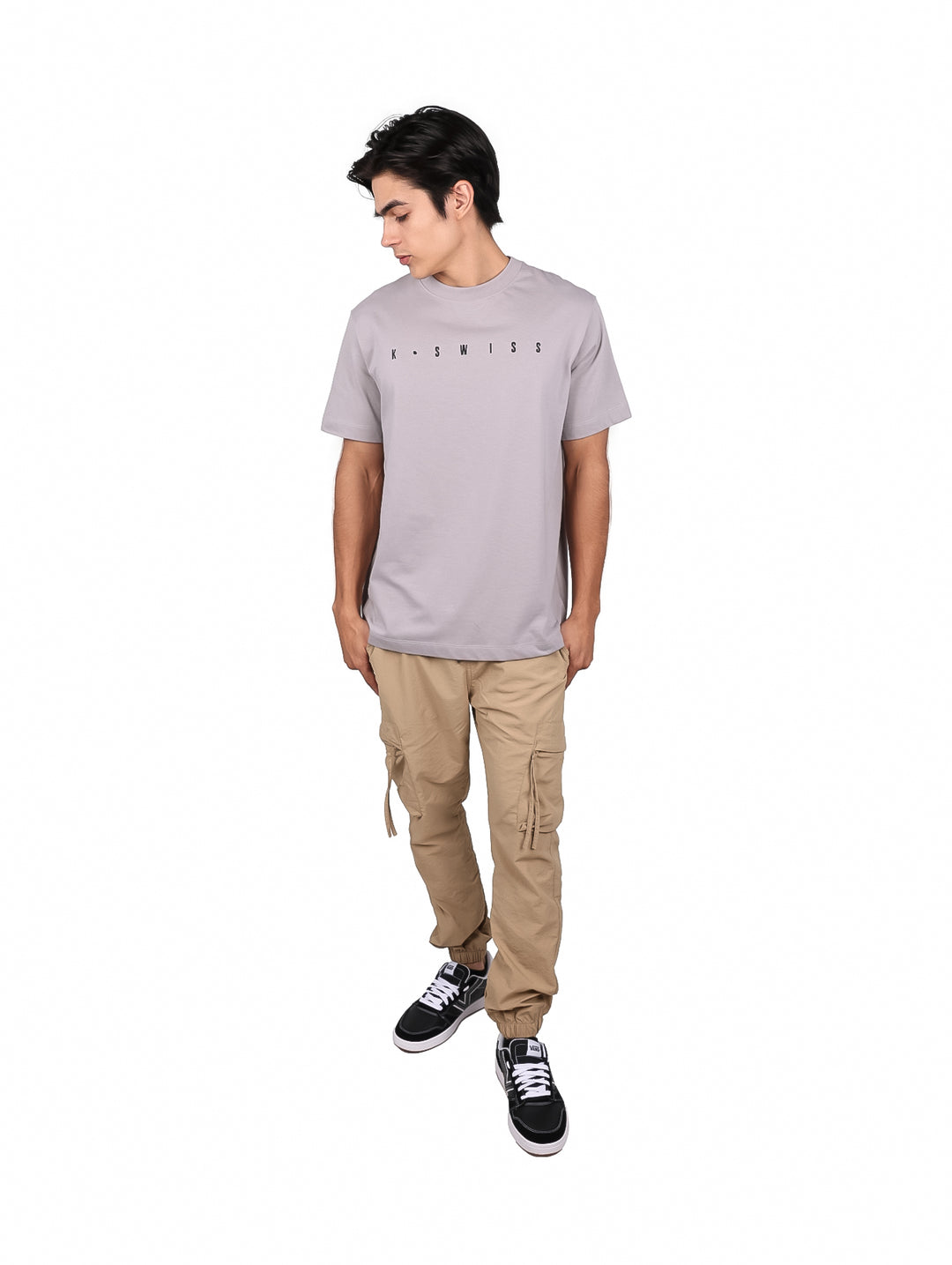 Hombre vistiendo una playera de manga corta color gris con el logo de K-Swiss en el pecho.