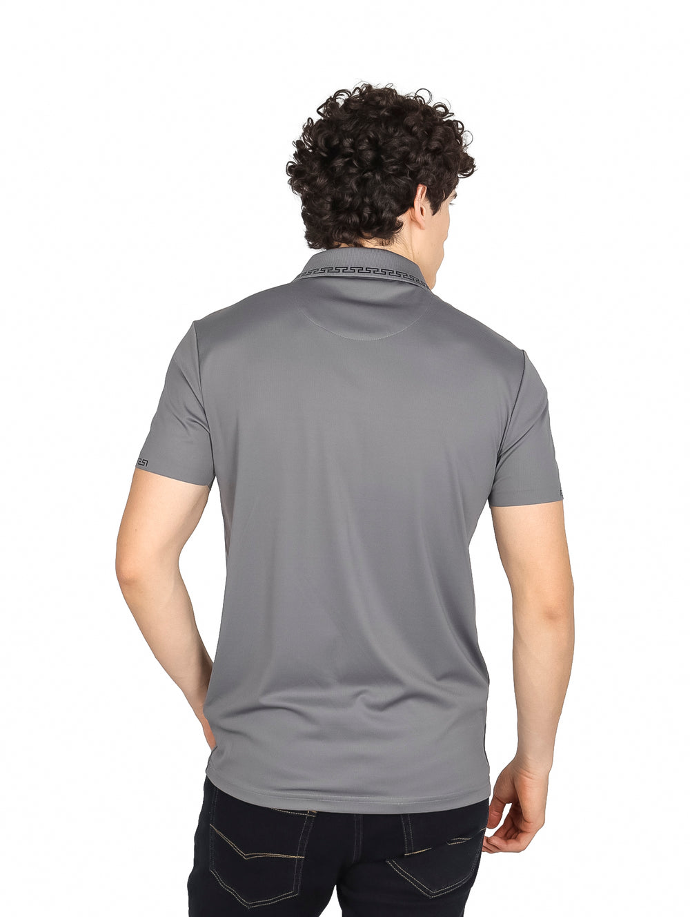 Hombre vistiendo una playera polo color gris oscuro con detalles decorativos en el cuello y mangas.