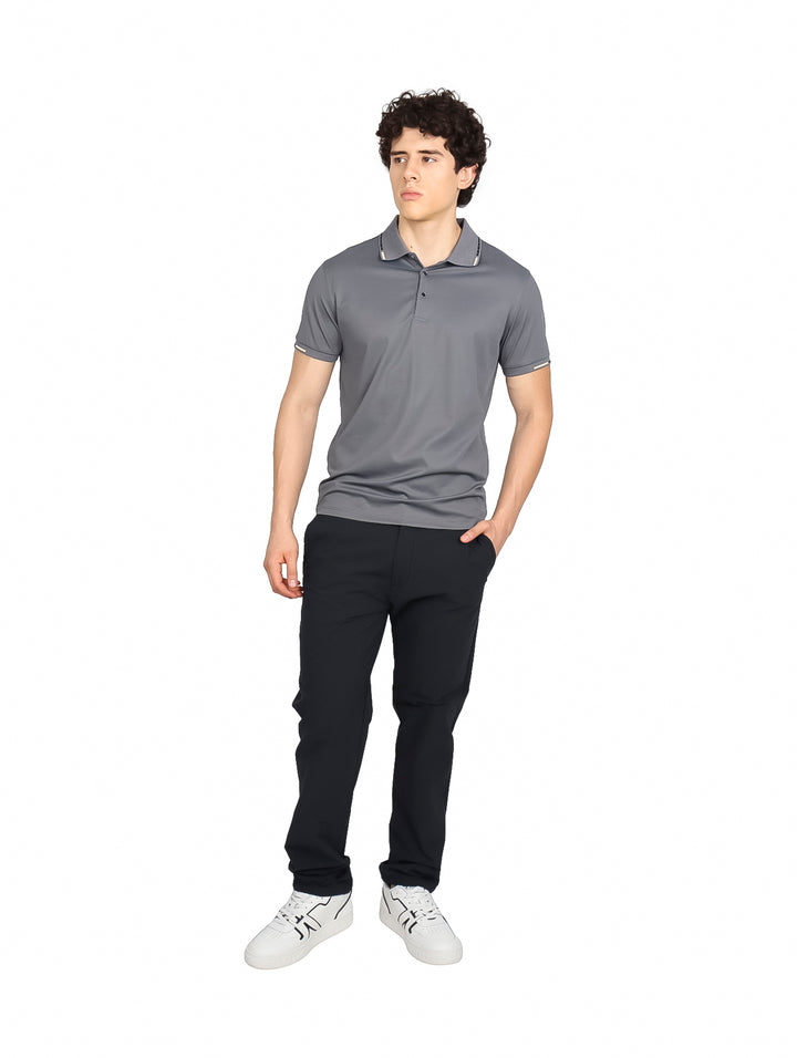 Hombre vistiendo playera polo Varesi color gris de manga corta con detalles blancos en cuello y mangas.