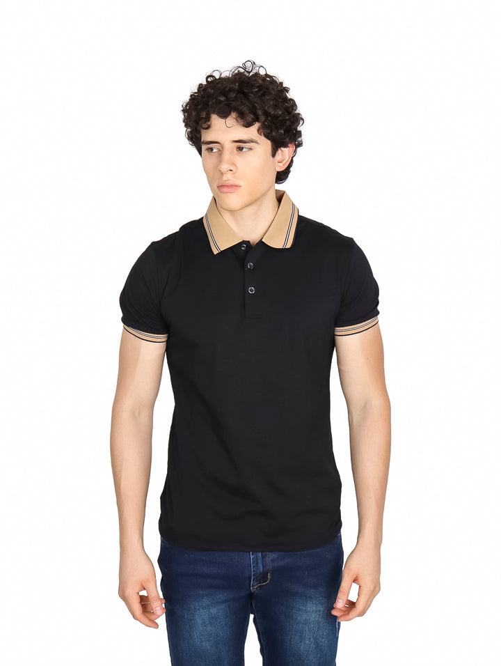 Hombre vistiendo playera polo color negro con detalles en beige en el cuello y puños de las mangas.