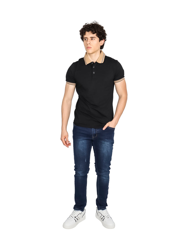 Hombre vistiendo playera polo color negro con detalles en beige en el cuello y puños de las mangas.