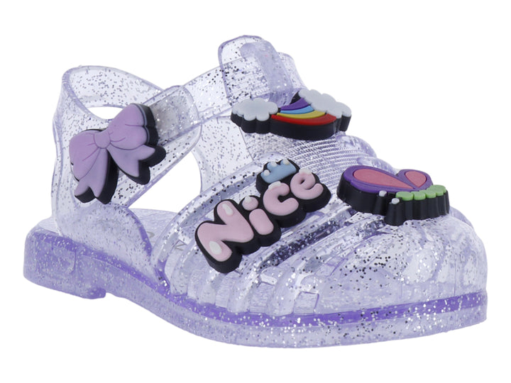 Sandalias infantiles color morado con glitter, decoradas con un moño y letras que dicen &