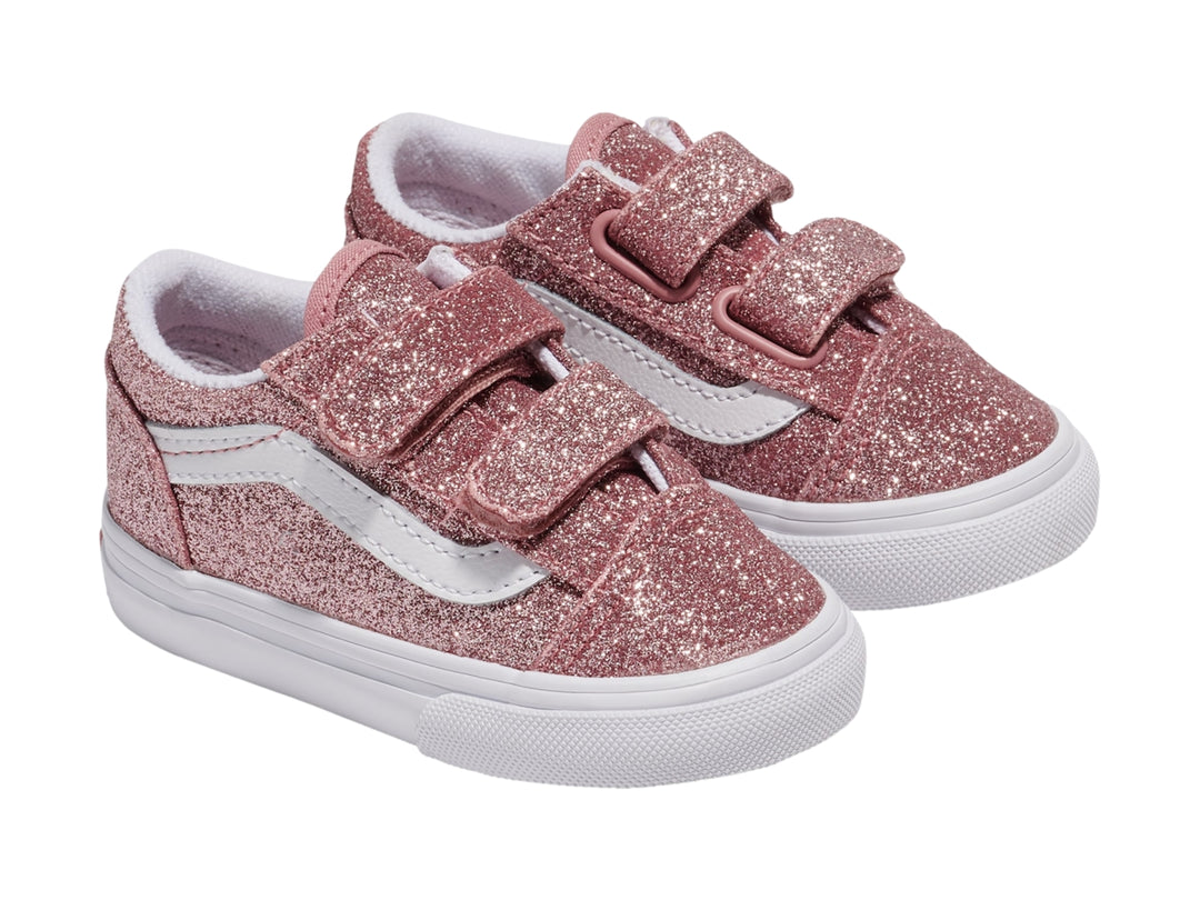 Tenis Vans Old Skool color rosa dorado con glitter, suela blanca y cierres de velcro.