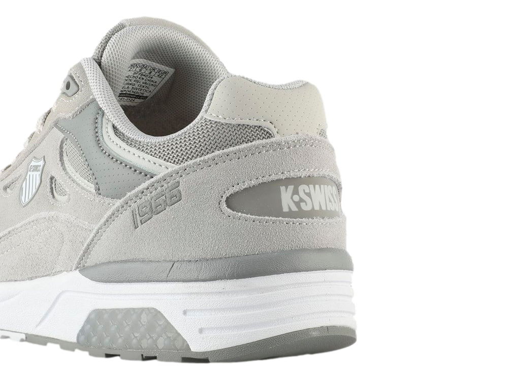 Tenis K-SWISS Contender en color gris con suela blanca, diseño deportivo con detalles en malla y gamuza sintética.