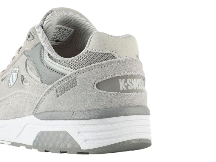 Tenis K-SWISS Contender en color gris con suela blanca, diseño deportivo con detalles en malla y gamuza sintética.