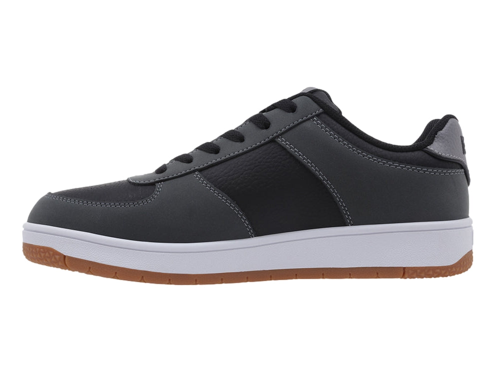 Tenis K-Swiss color gris oscuro con suela blanca y base de goma marrón, vista lateral.
