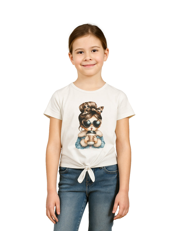 Niña vistiendo blusa color ivory con estampado gráfico y nudo frontal.