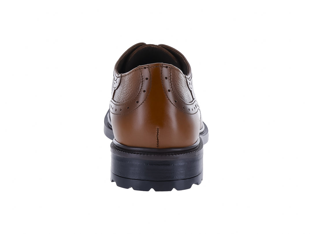 Zapato formal de cuero color miel con detalles perforados y suela negra.