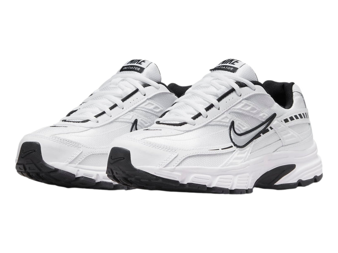 Tenis Nike Initiator blancos con detalles en negro y plata para mujer.