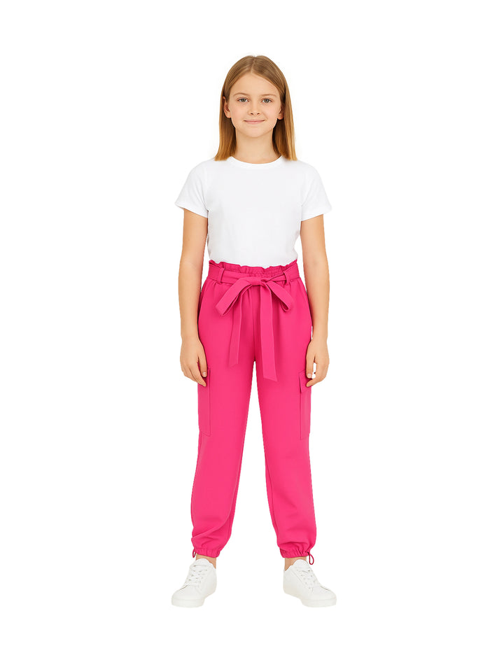 Niña vistiendo pantalón cargo color fucsia con cinturón de lazo y camiseta blanca.
