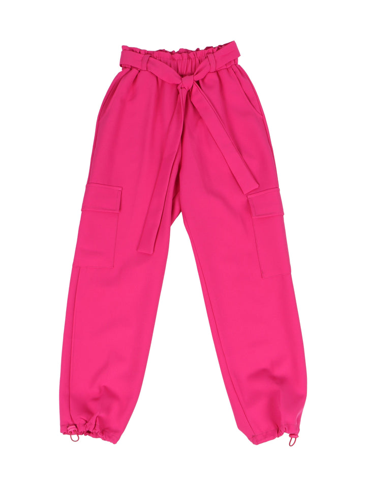 Niña vistiendo pantalón cargo color fucsia con cinturón de lazo y camiseta blanca.