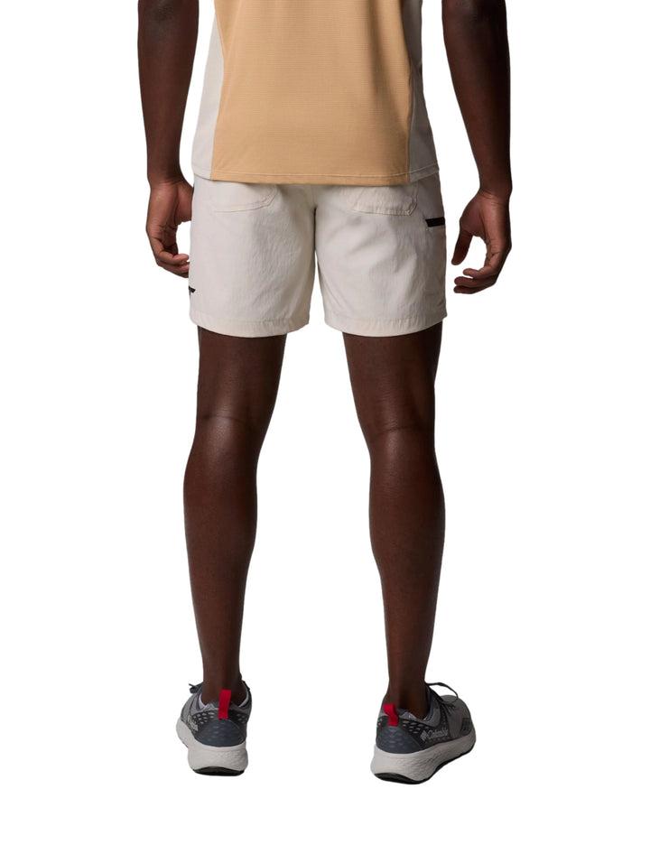 Hombre vistiendo pantalones cortos Columbia color Dark Stone de estilo ligero y deportivo.