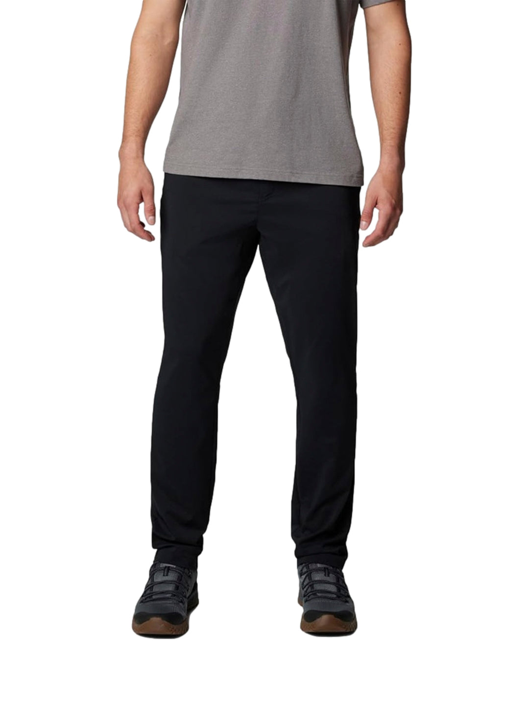 Hombre vistiendo pantalones tipo chino color negro de la marca Columbia con camiseta gris.