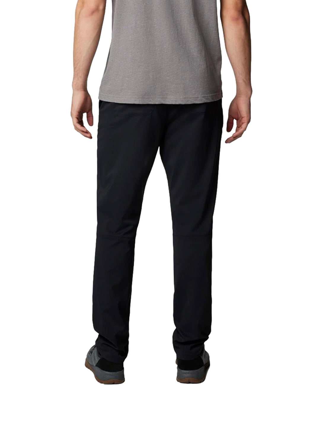 Hombre vistiendo pantalones tipo chino color negro de la marca Columbia con camiseta gris.