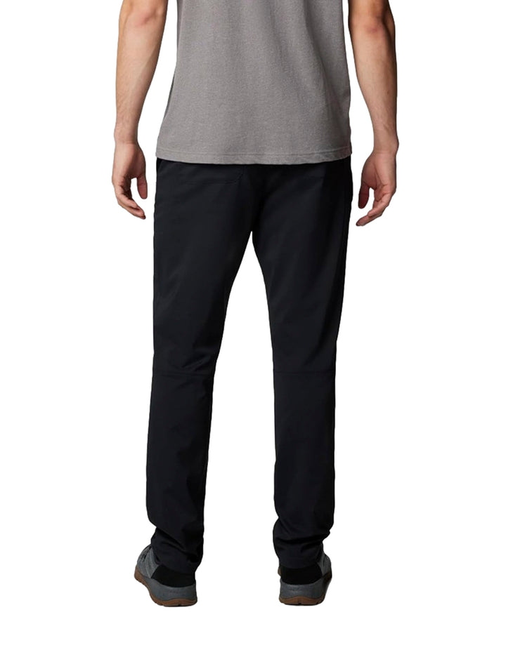 Hombre vistiendo pantalones tipo chino color negro de la marca Columbia con camiseta gris.