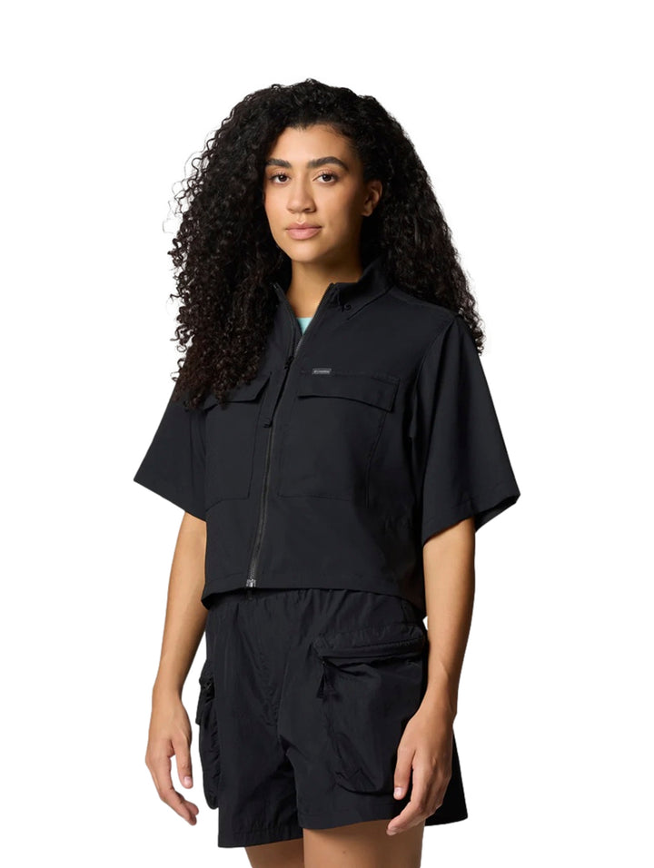 Mujer vistiendo camisa negra de manga corta estilo utilidad y shorts negros de la marca Columbia.