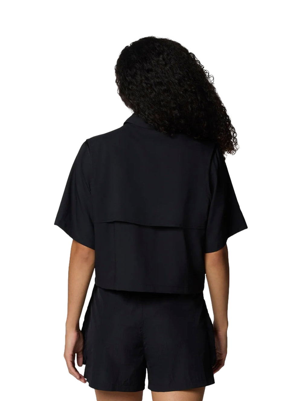 Mujer vistiendo camisa negra de manga corta estilo utilidad y shorts negros de la marca Columbia.