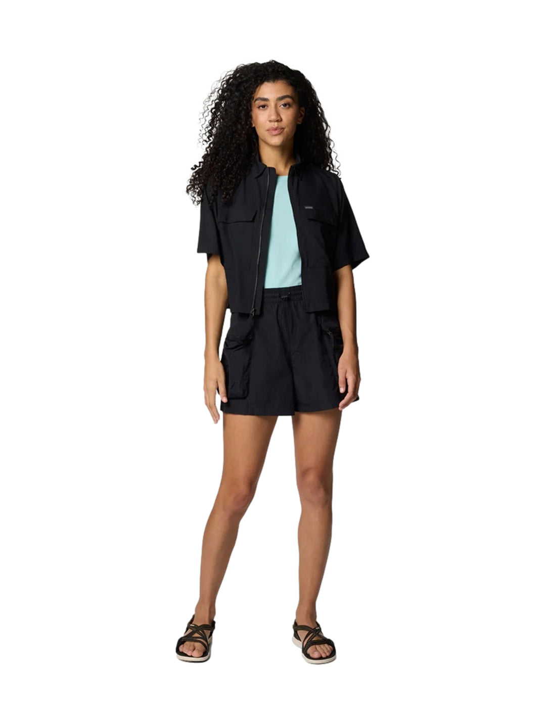 Mujer vistiendo camisa negra de manga corta estilo utilidad y shorts negros de la marca Columbia.