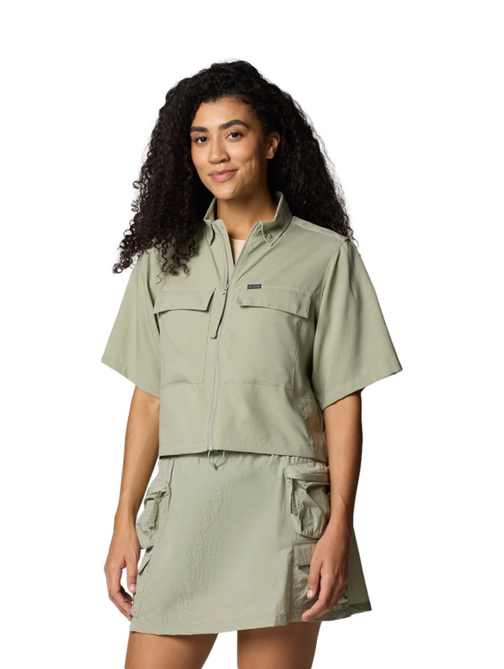 Mujer vistiendo camisa de manga corta y cuello en color safari con bolsillos frontales.