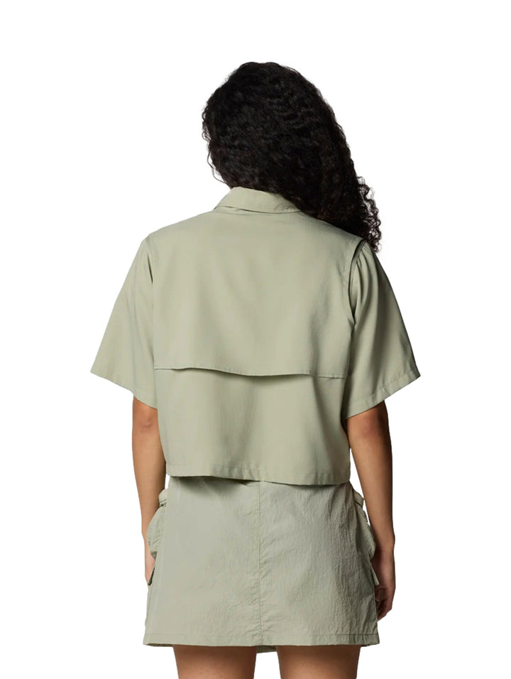 Mujer vistiendo camisa de manga corta y cuello en color safari con bolsillos frontales.
