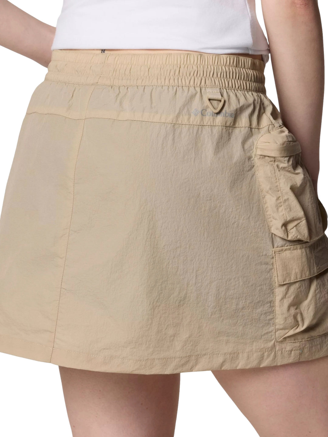 Mujer vistiendo una falda pantalón cargo de color beige con bolsillos laterales.