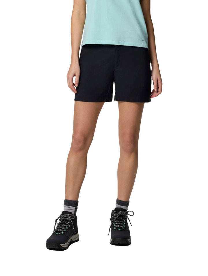 Mujer vistiendo shorts deportivos color negro de la marca Columbia con botas de senderismo.