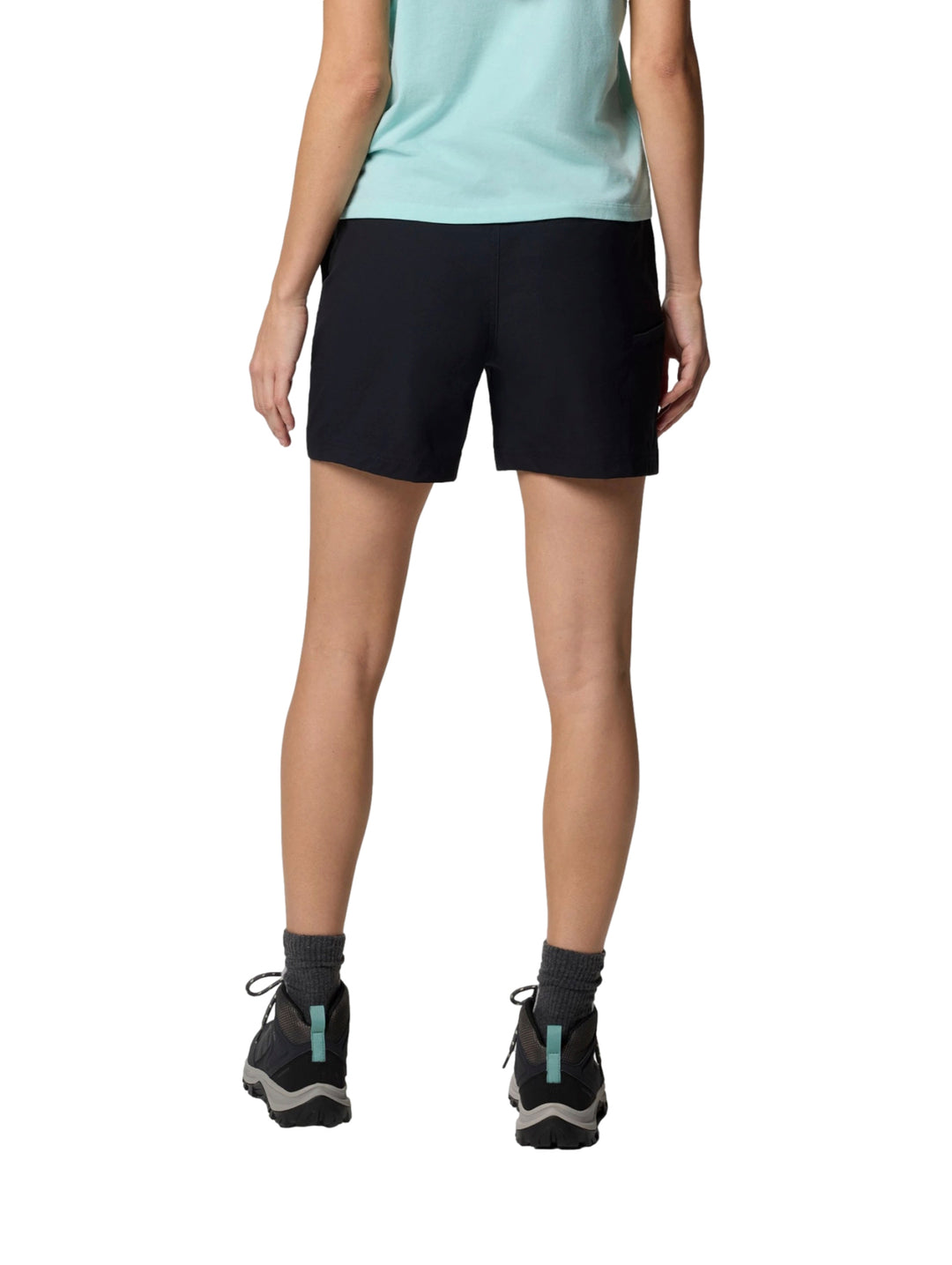 Mujer vistiendo shorts deportivos color negro de la marca Columbia con botas de senderismo.