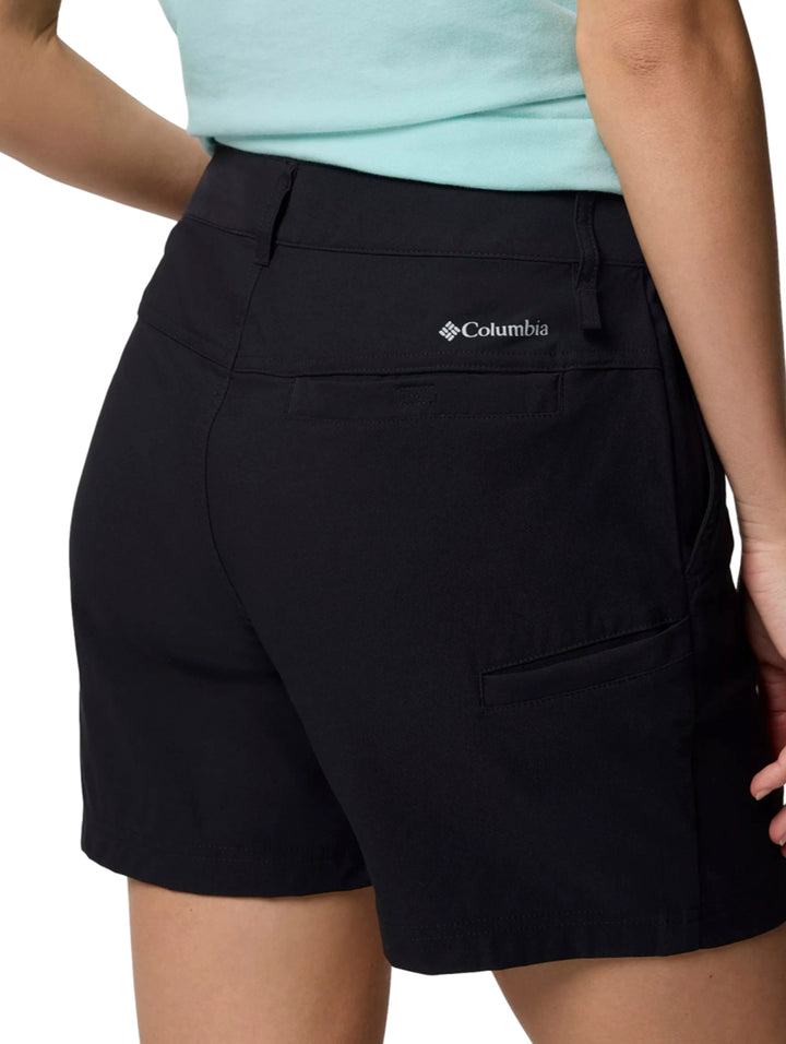 Mujer vistiendo shorts deportivos color negro de la marca Columbia con botas de senderismo.
