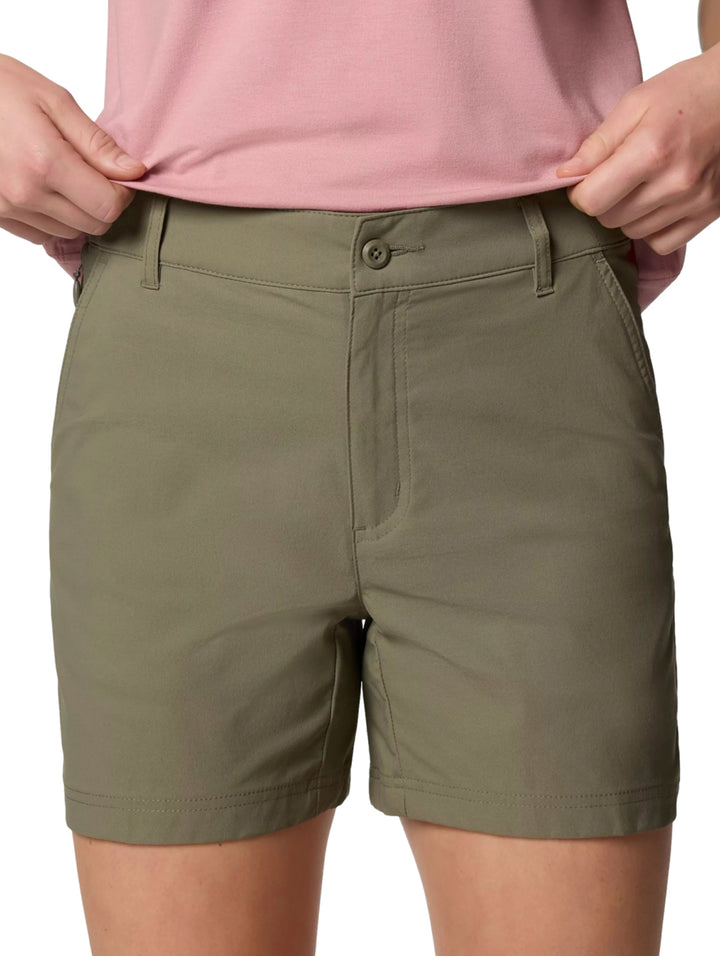Mujer vistiendo shorts Columbia Leslie Falls II en color Stone Green y playera rosa.