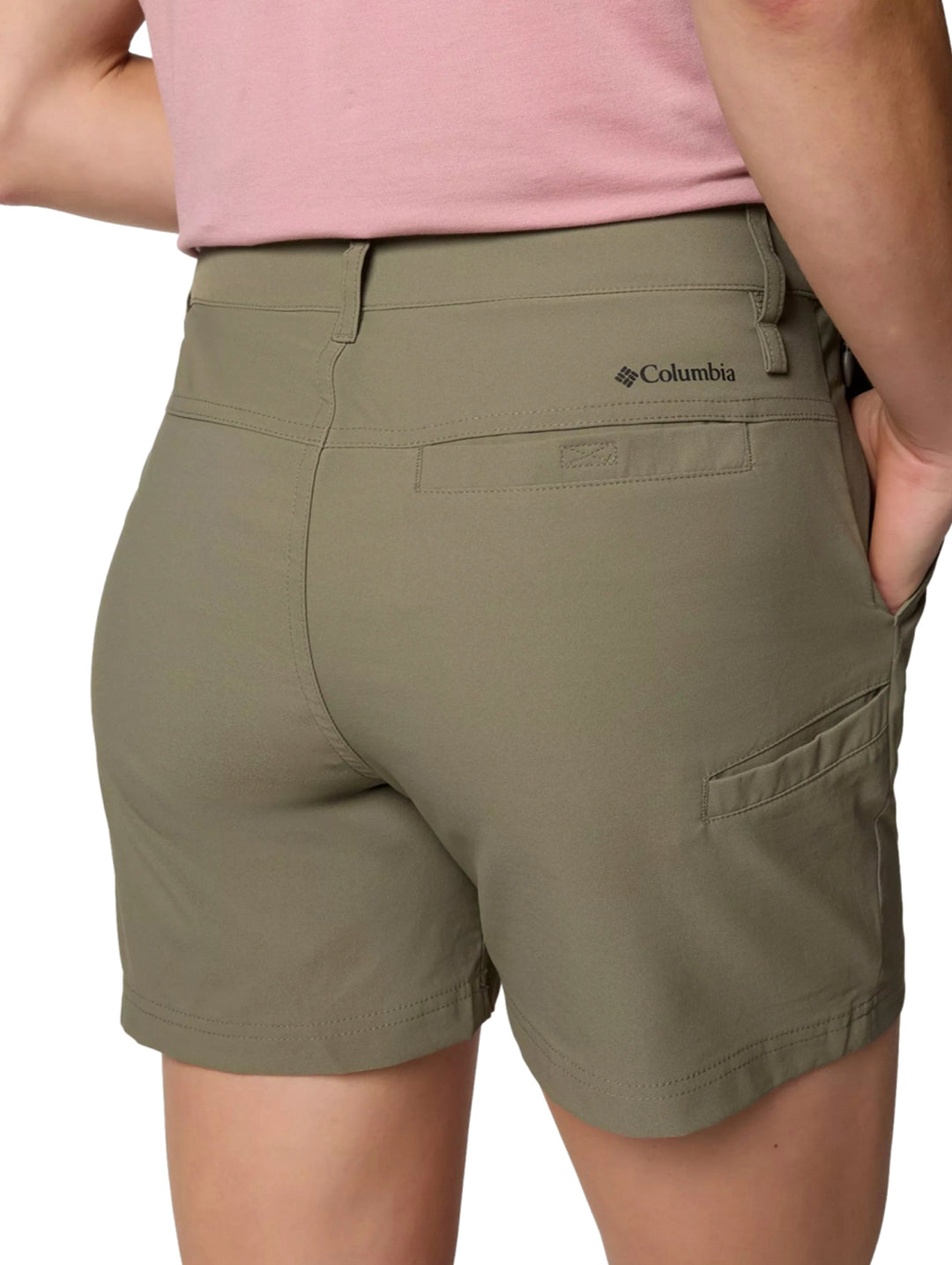 Mujer vistiendo shorts Columbia Leslie Falls II en color Stone Green y playera rosa.