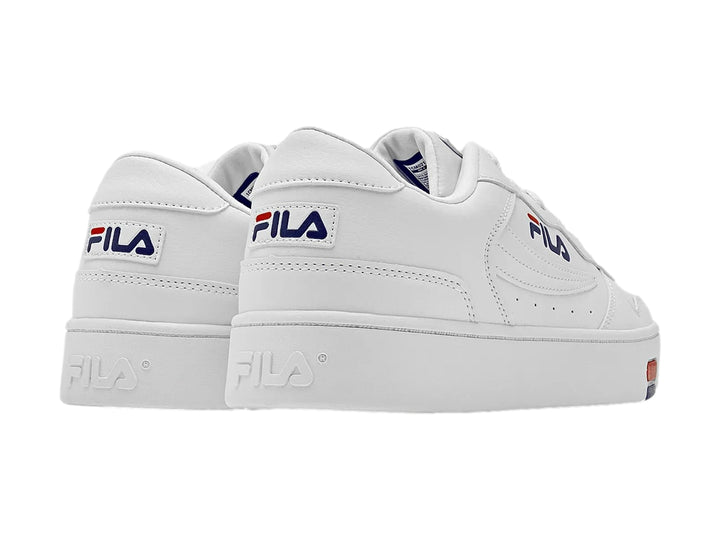 Tenis blancos FILA de corte bajo con detalles en azul y rojo en el costado y la suela.