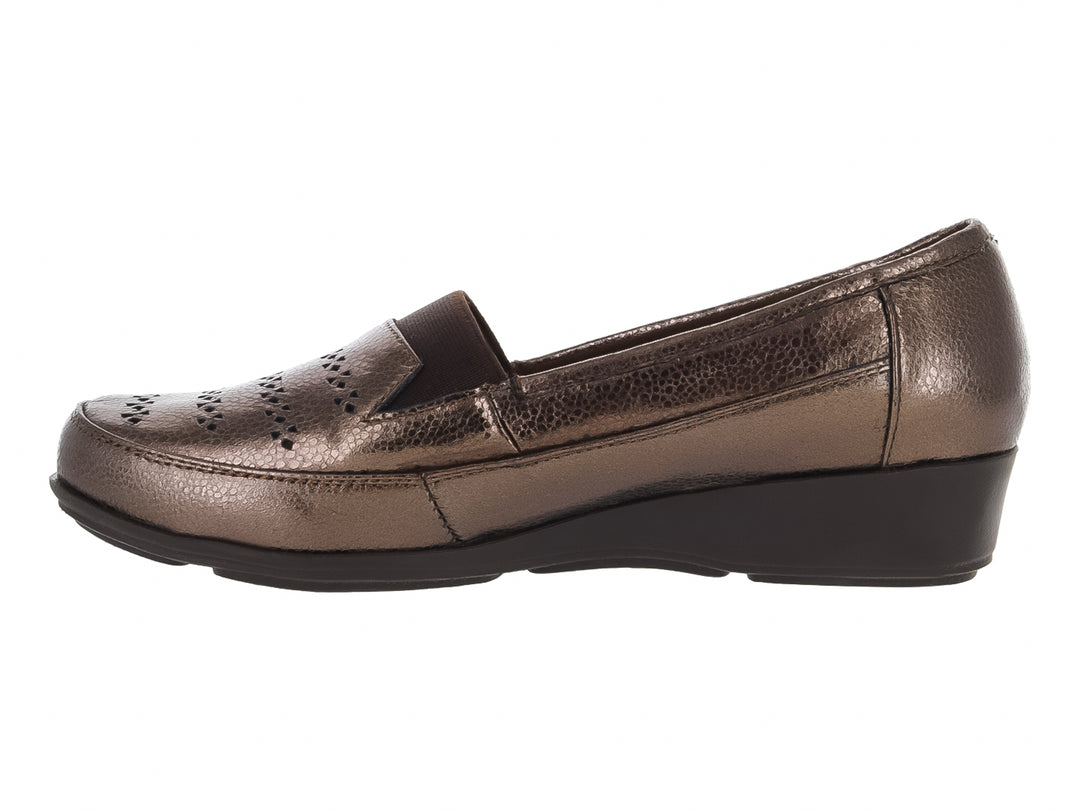 Zapato plano tipo mocasín en color bronce metálico con suela negra y detalles perforados en la parte superior.