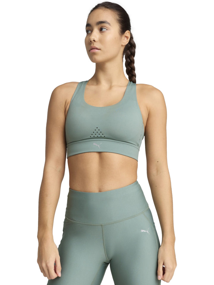 Mujer vistiendo un top deportivo PUMA color verde luna con diseño ajustado y cuello redondo.