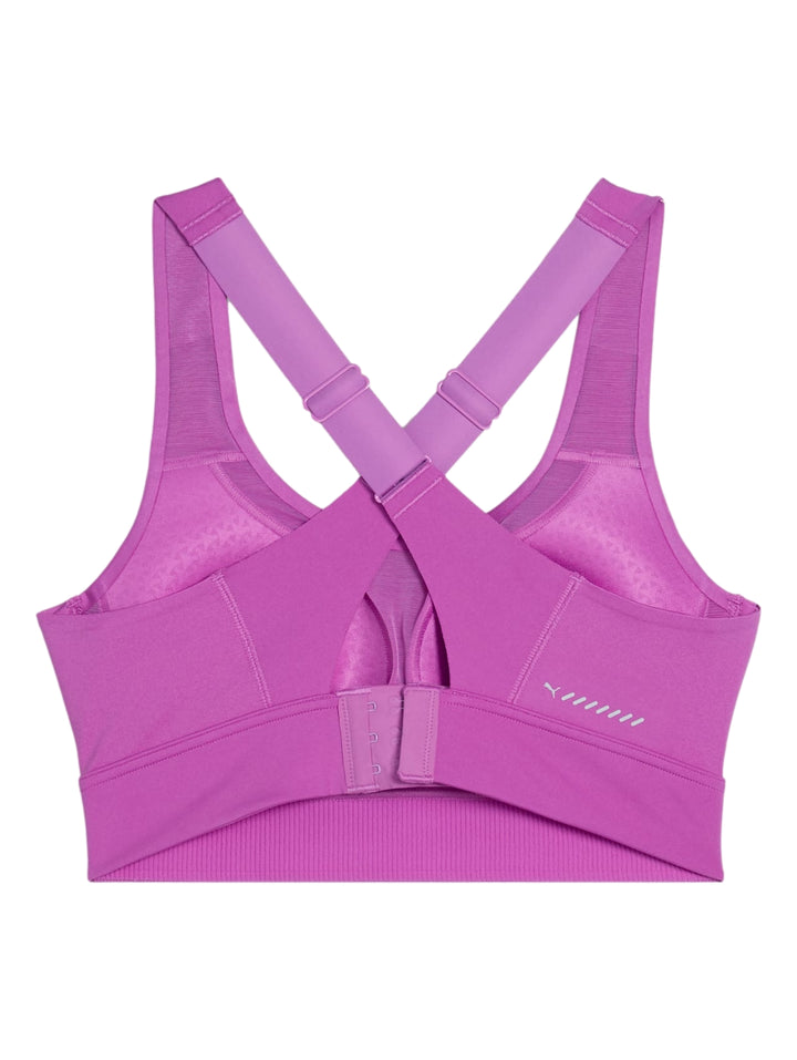 Mujer vistiendo un sujetador deportivo PUMA en color morado Wild Berry.