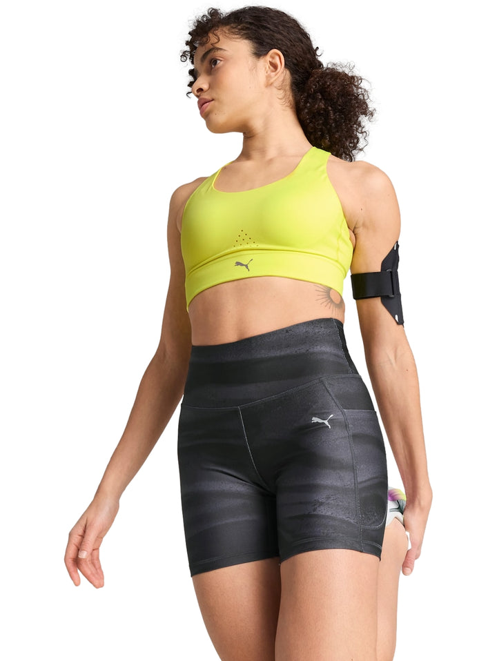 Top deportivo PUMA color amarillo limón usado por una mujer.