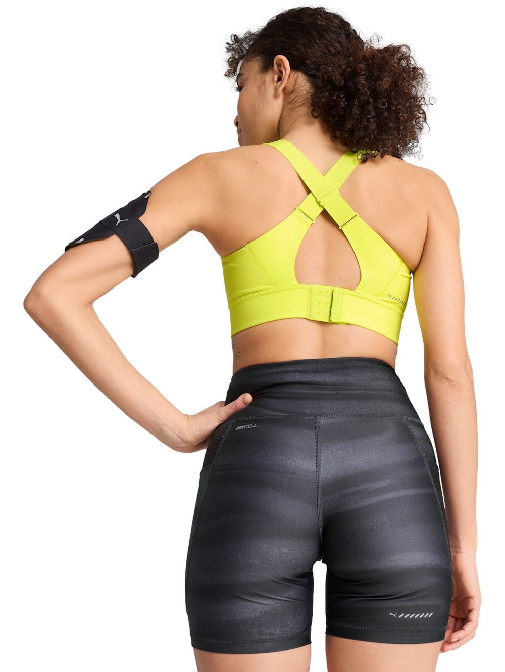 Top deportivo PUMA color amarillo limón usado por una mujer.