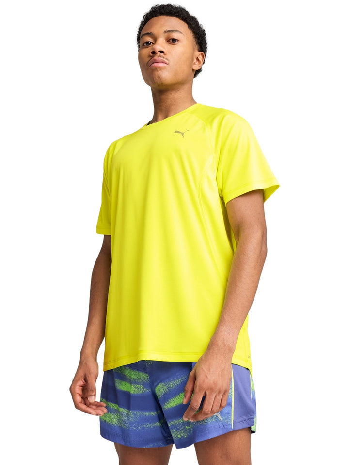 Hombre vistiendo una camiseta deportiva PUMA de color amarillo limón con cuello redondo y manga corta.