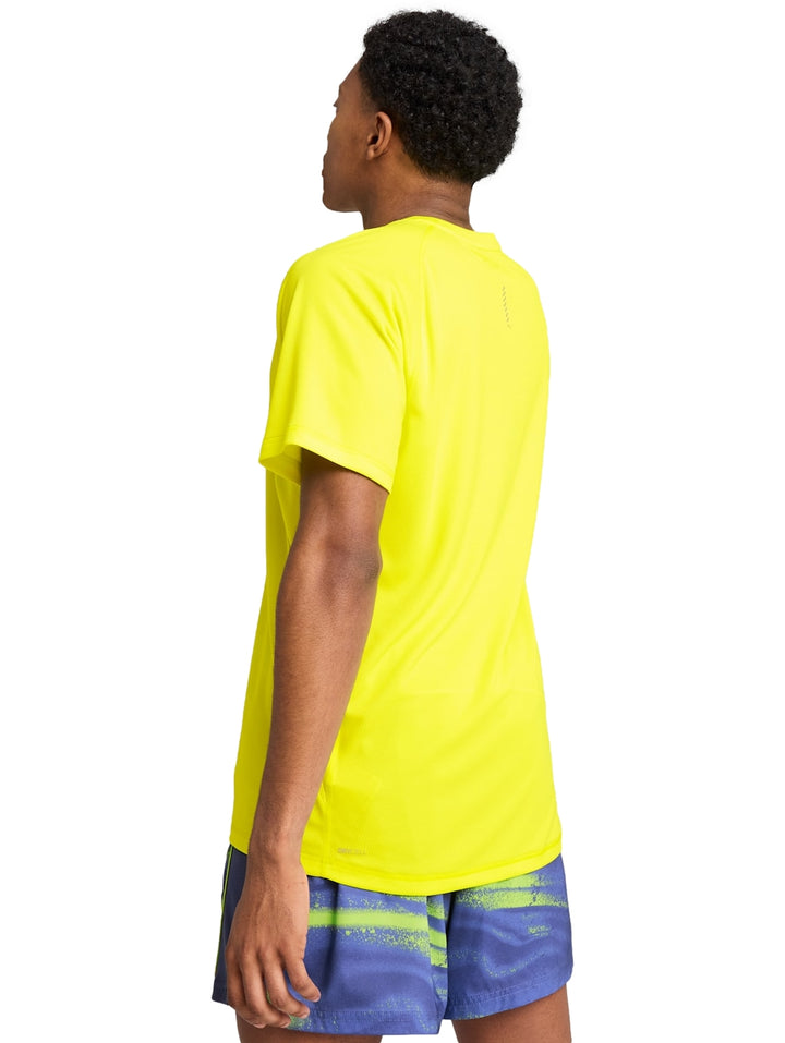 Hombre vistiendo una camiseta deportiva PUMA de color amarillo limón con cuello redondo y manga corta.