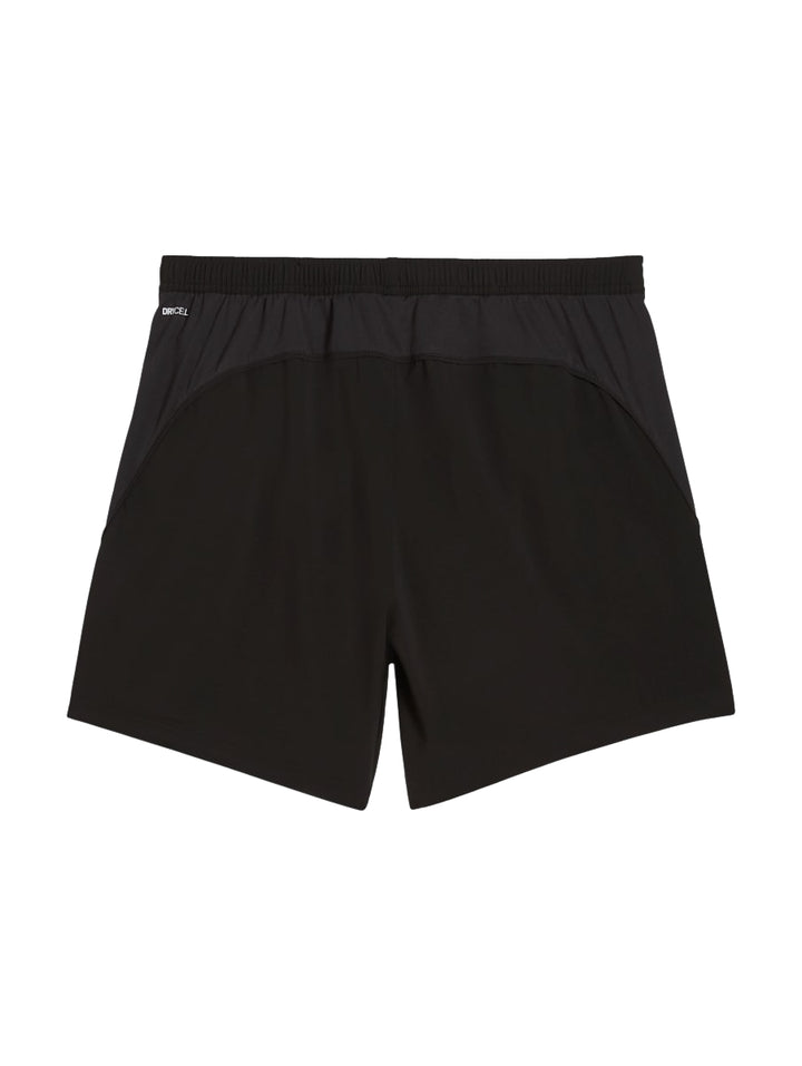 Hombre vistiendo shorts deportivos PUMA de color negro, diseñados para correr.