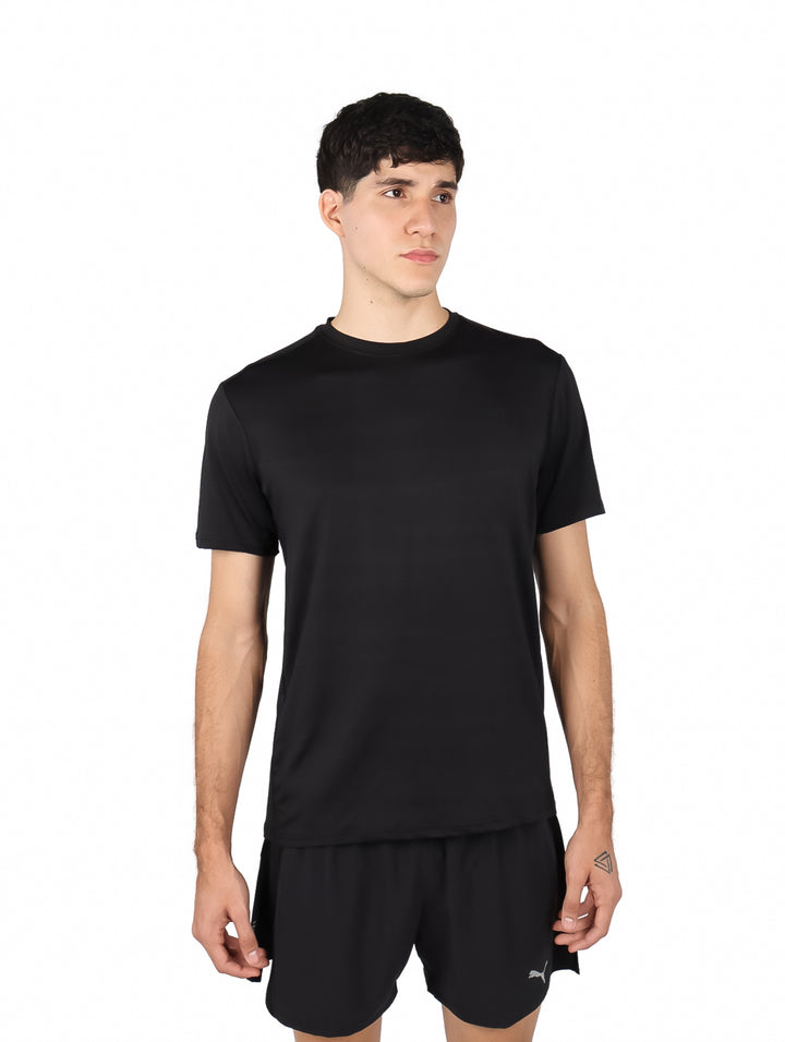 Hombre vistiendo una playera deportiva de manga corta color negro sobre fondo blanco.