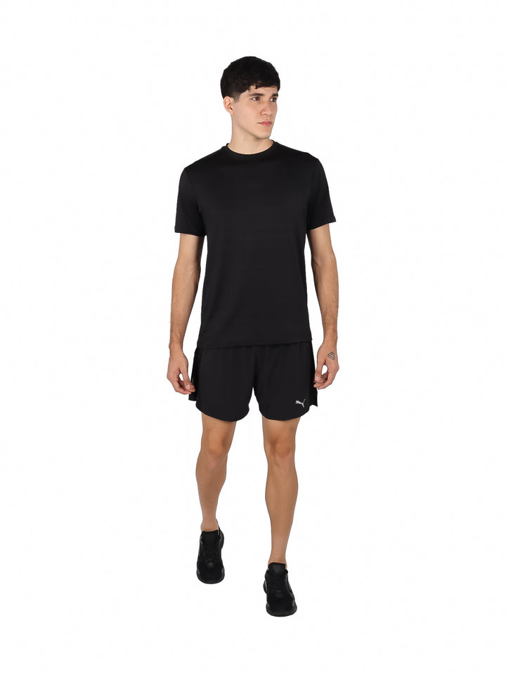 Hombre vistiendo una playera deportiva de manga corta color negro sobre fondo blanco.