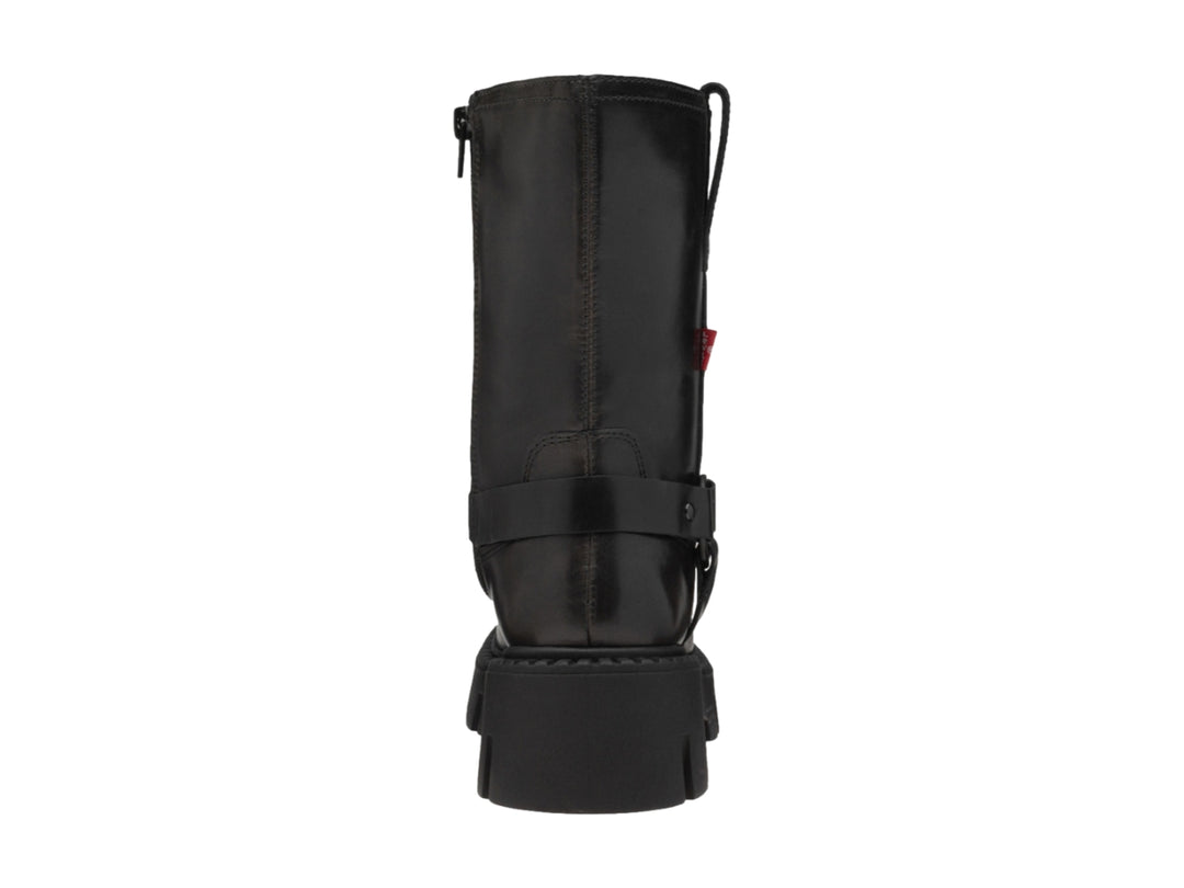 Bota negra de material sintético con suela track gruesa y correa con hebilla.