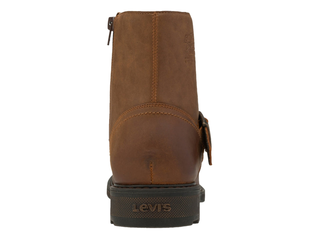 Bota casual color ocre para hombre con correa y hebilla metálica, suela marrón oscuro dentada.