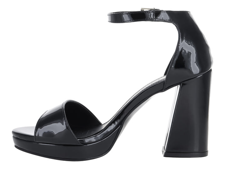 Sandalia negra de charol con tacón grueso, plataforma y correa al tobillo con hebilla plateada.