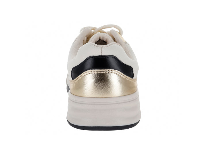 Tenis Clasben color crema con detalles en oro metálico y suela blanca.