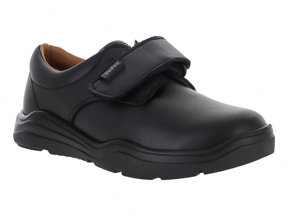 Zapato infantil color negro con cierre de velcro y suela gruesa.