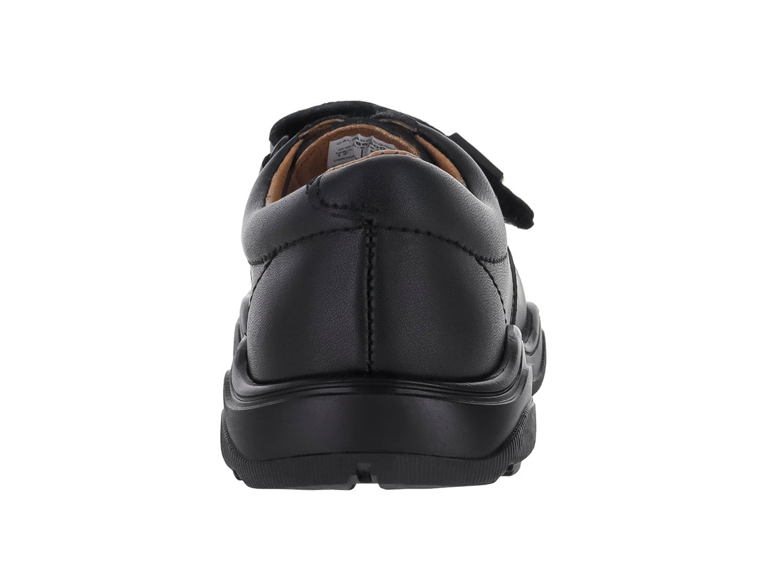 Zapato infantil color negro con cierre de velcro y suela gruesa.