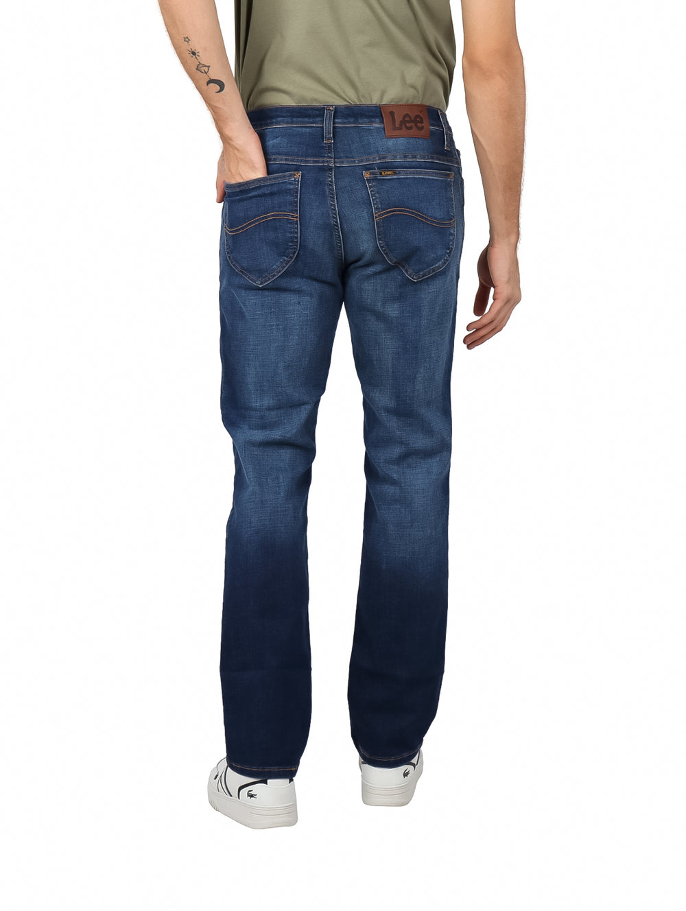 Hombre vistiendo pantalones LEE slim fit en color azul índigo con efecto lavado.