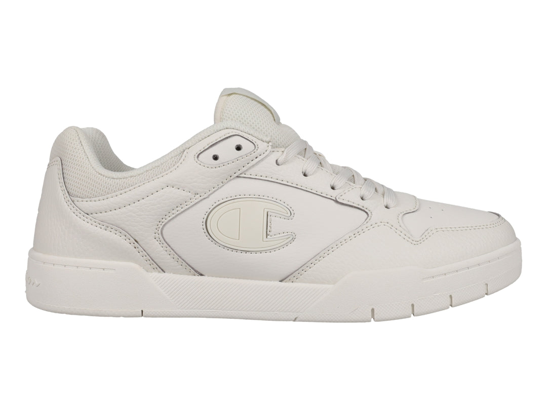 Tenis Champion color hueso, diseño deportivo de corte bajo con logo lateral.
